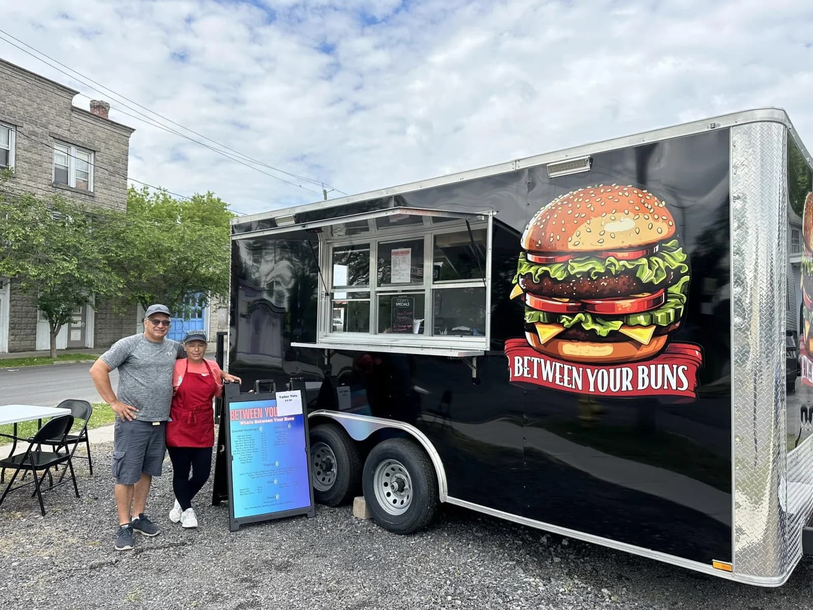 Between Your Buns food trailer with its serving window and burger logo